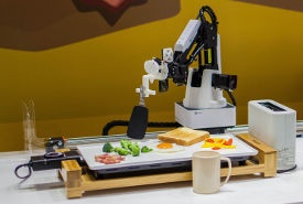 調理ロボットの一例：ホットプレートの食材をヘラで返すロボット